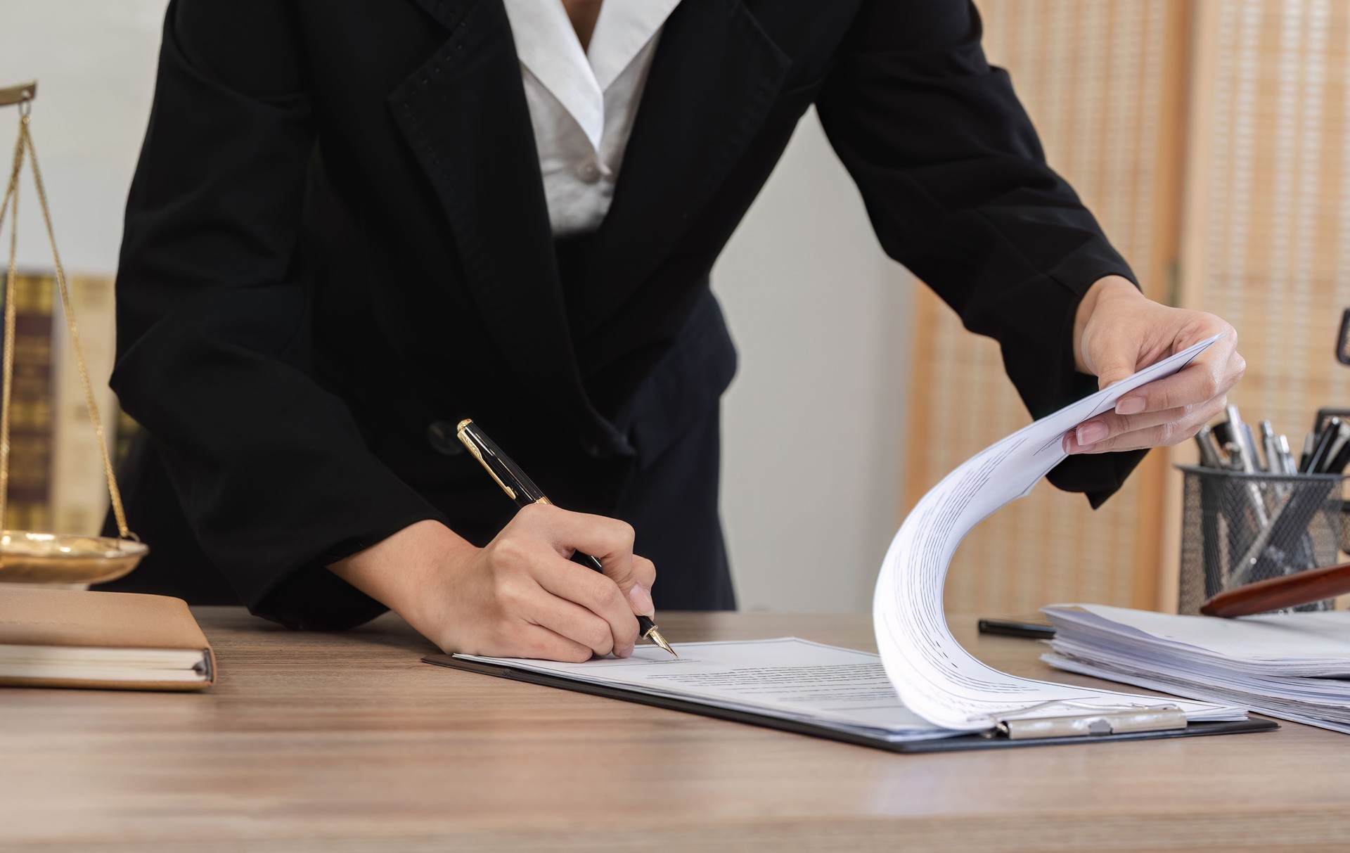 Young Lawyer Introducing and Signing Contract Documents with Clients in a Modern Office Setting